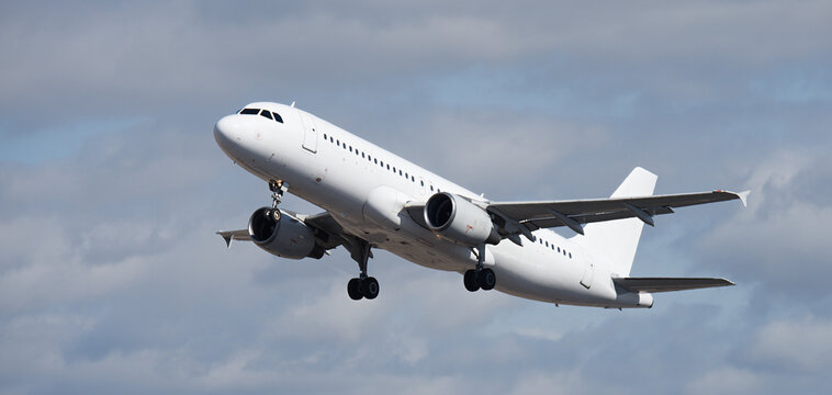 Airplane take off on the blue sky, with white clouds. Aircraft flying on sky background. White passenger jet plane in the blue sky. Low angle view of Airplane flying under blue sky, with white clouds