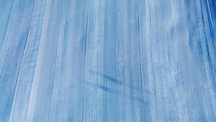Wide alpine mountain panorama with snowy ridges and ski infrastructure under clear blue sky, representing a winter resort landscape and seasonal tourism environment