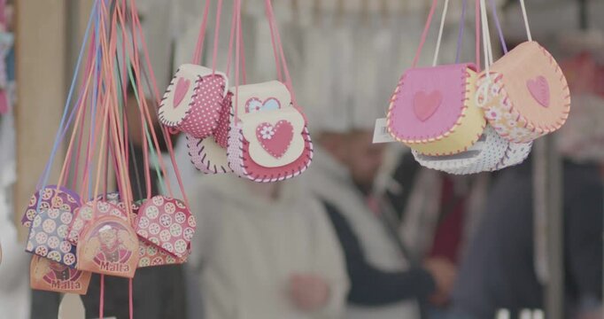 Colorful handmade purses hanging at a market