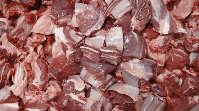 Detailed view of raw pork meat cut into chunks for food processing