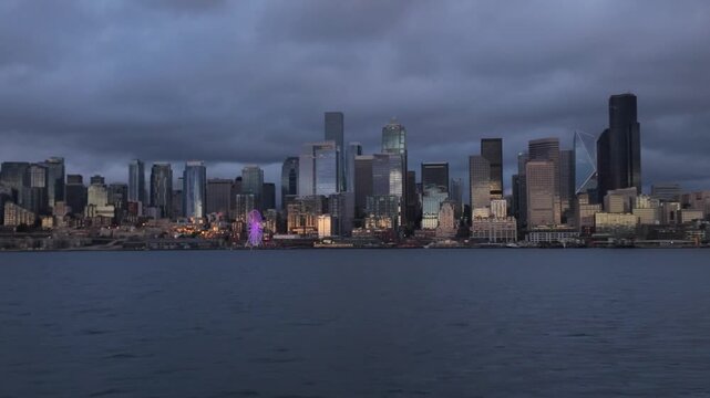 Gimbal wide panning shot of the downtown Seattle skyline as seen from a moving Salish Sea Tour boat during sunset in the Pacific Northwest. 4K at 30 FPS