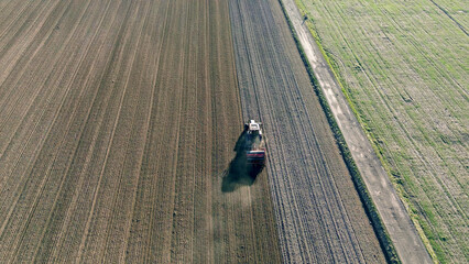 Top-down view of ploughing tractor on farmland © AlexGo