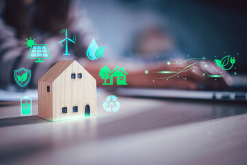 Wooden house model with sustainable eco-friendly green energy icons including solar and wind power for net zero living concept, Green Building, Carbon footprint, Save earth, Ethical investment © HappyEva
