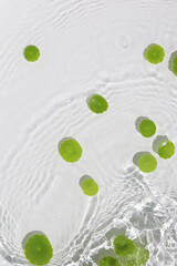 Green pennywort leaves floating on clear water with soft ripples.