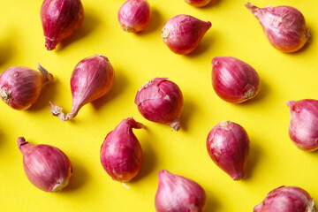 Red shallots on yellow background.