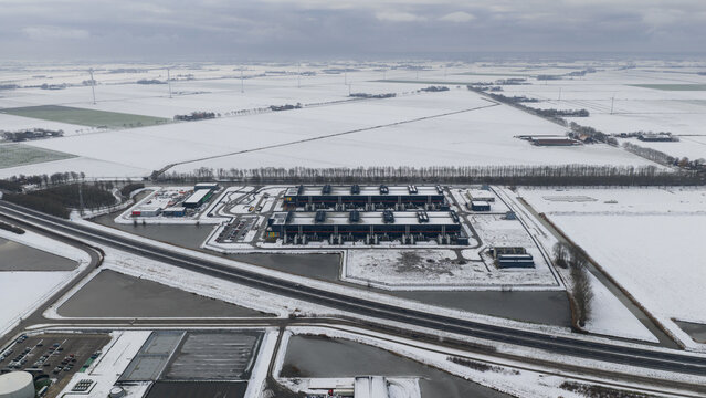 Aerial view of a stark, snow-covered landscape where a modern datacenter stands out against the icy fields, Datacenter Middenmeer, North Holland, Netherlands.