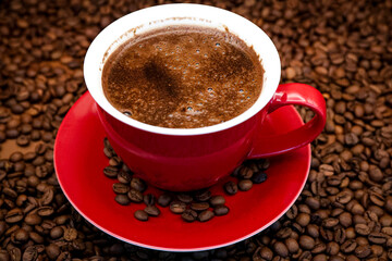 Red coffee cup on a coffee beans background
