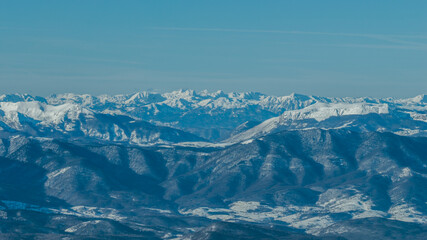 Wide panoramic view of Treskavica mountain range in winter, revealing snow covered ridges, deep valleys, and expansive alpine wilderness