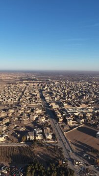 Drone shot overlooking the city of Deir ez-Zor in eastern Syria. The footage captures the urban landscape, traditional architecture, and the strategic flow of the Euphrates River.