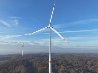 Wind Turbines Generating Renewable Energy Above Forest Landscape