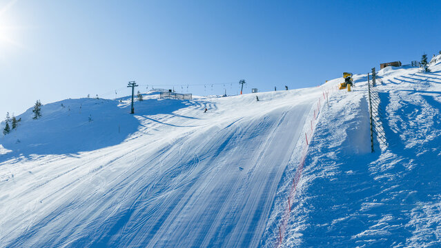 Alpine ski slopes intersecting across mountain terrain with visible chairlifts, showing winter sports infrastructure and resort landscape in clear conditions