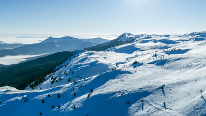 Obraz premium Panoramic alpine mountain view with snowy ridges and distant valleys, captured in winter conditions, representing a well known ski destination and natural landscape