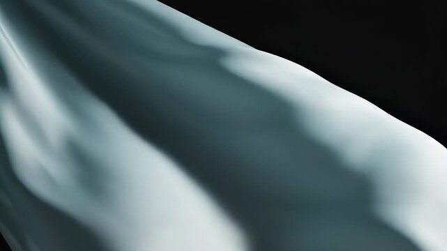 A blue fabric waving in the wind against a black background with folds and creases