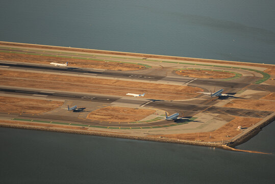 San Francisco, United States - 19 October 2024: Aerial view of the airport runway, where the stark lines of the tarmac meet the shimmering blue of the surrounding bay.