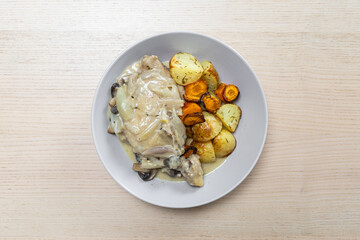 A plate of cider braised chicken and root vegetables.