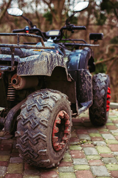 Muddy ATV parked outdoors rear view