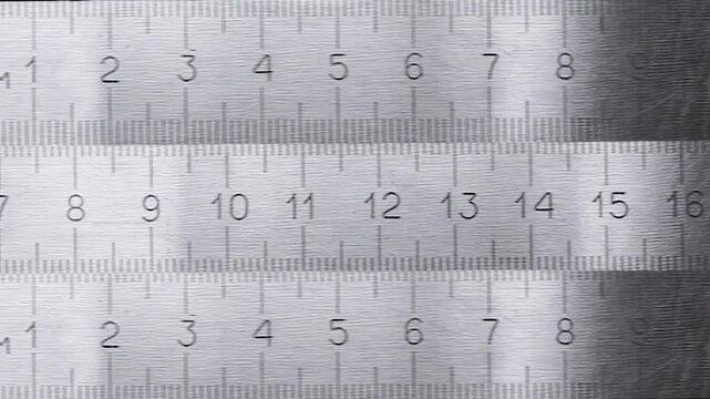 Close-up of a silver metal ruler. A metal ruler with metric measurements on a black background. Stop motion animation