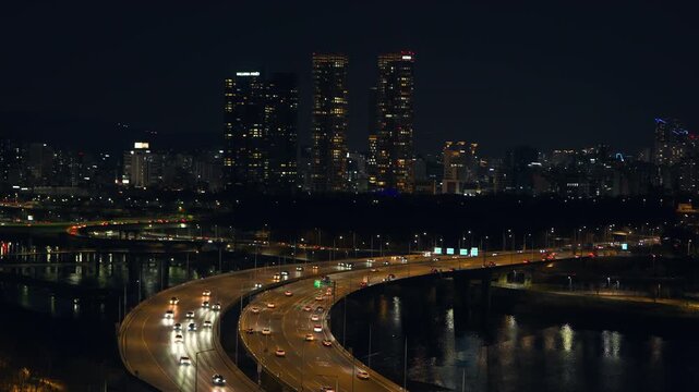 Night drone shot of car lights on highway ramps near Acro Forest and Galleria Foret skyscrapers in Seongsu-dong district of Seoul at night