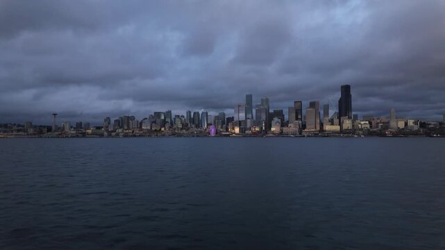 Gimbal wide shot from a moving boat of the Seattle skyline during evening on Elliott Bay in Washington. 4K at 30 FPS