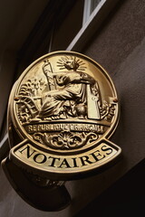 Notaires. Plaque dor&eacute;e d'office notarial sur fa&ccedil;ade dans la rue.