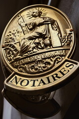 Notaires. Plaque dor&eacute;e d'office notarial sur fa&ccedil;ade dans la rue.