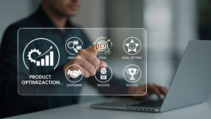 A person interacting with a holographic interface displaying product optimization concepts and business goals while working on a laptop.