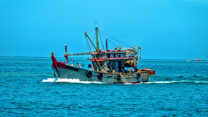 Obraz premium An old wooden fishing schooner goes out to catch fish and shrimp. Malaysia, South China Sea.