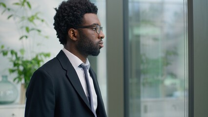 Creative thoughtful African American man business male entrepreneur businessman thinking idea startup corporate solution serious look at window in office manager job pondering decide difficult idea