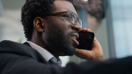 Close up angry emotional stressed African American business man yelling arguing mobile phone call in office ethnic irritated annoyed businessman male guy talking smartphone work problem job quarrel