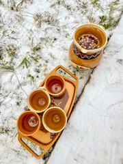 Ceramic cups and pitcher outdoors on snowy day