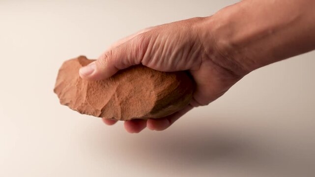Prehistoric flint knife or cutter, biface, Neolithic. Hand manipulating the tool; its edges are visible. Perfectly preserved. 4K video