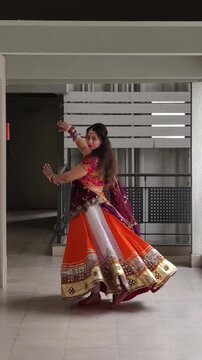 Indian woman performing Garba dance in vibrant chaniya choli with full flair, golden lace details, oxidized jewellery and flowing dupatta, celebrating Navratri, tradition, rhythm and festive culture.
