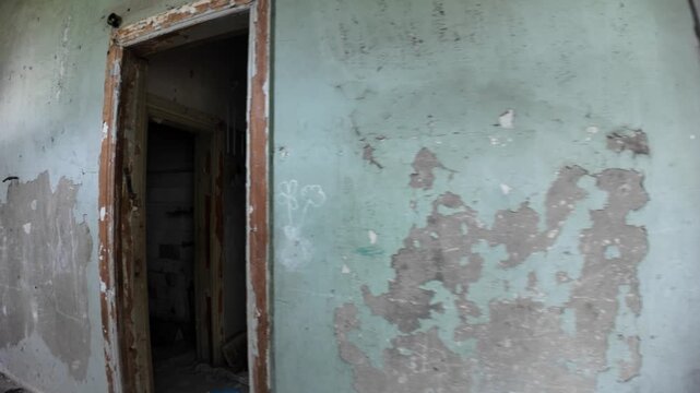 Crumbling walls and debris litter the floor of a decaying hallway, remnants of the once-popular Medea Sanatorium in Tskaltubo, Georgia, a relic of the Soviet era abandoned after the USSR's collapse