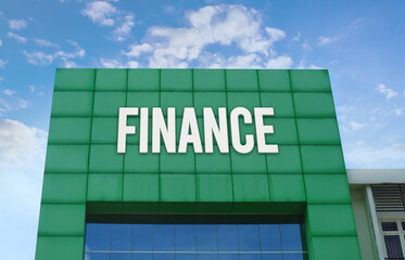 Modern green facade with a large FINANCE sign against a cloudy blue sky.