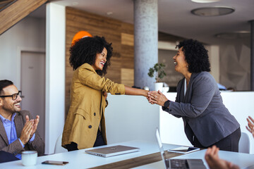 Naklejka premium Excited Business Colleagues Welcome Each Other With Handshake In Modern Open Office During Team Meeting