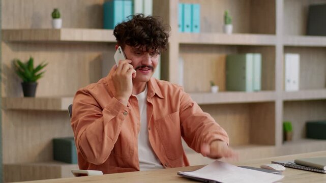 Angry mad furious Caucasian business man arguing mobile phone holding papers talking businessman argue dissatisfied with documents mistake conflict quarrel male guy talk smartphone in office company