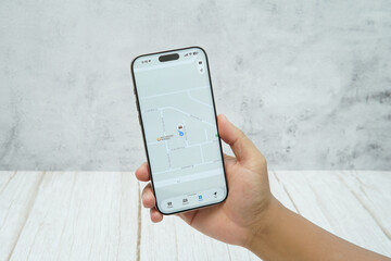 Hand holding smartphone displaying generic tracking application interface. Concept of location tracking, activity monitoring, and mobile technology for business and personal use.