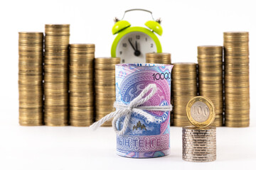 A conceptual story about the Kazakh financial system, featuring a stack of 10,000 tenge bills, 100 tenge coin and stacks of coins on a white background.