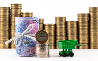 A conceptual story about the Kazakh financial system, featuring a stack of 10,000 tenge bills, 100 tenge coin and stacks of coins on a white background.