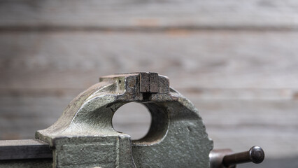Worn metal bench vise jaws in workshop close up
