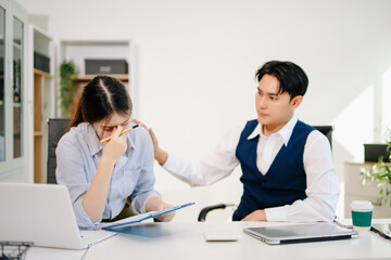 Obraz premium Stressed business man and woman working in office under pressure and deadline. Concept of work stress, burnout, mental health, business problem and teamwork challenge.