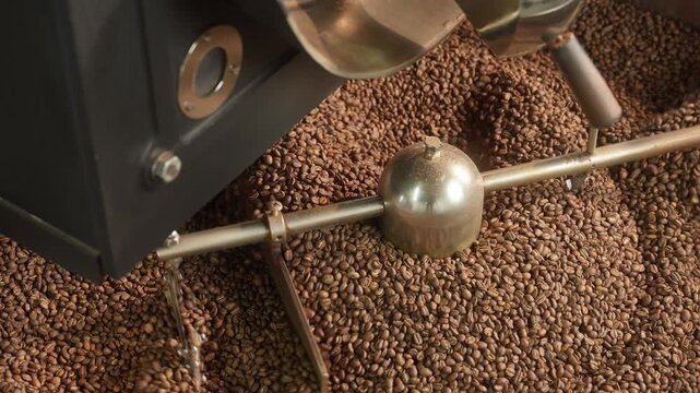 Fresh roasted coffee beans cooling in large industrial mixer machine roaster blend at modern factory aromatic brown grains blending mixing cocoa roasting closeup view of equipment production process