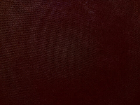 deep maroon textured fabric closeup revealing subtle diagonal weave for luxurious wallpaper or banner with copy space
