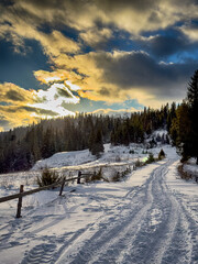 Mystical snowy Carpathian peaks under cloudy skies in the sunny weather