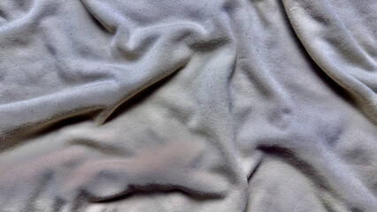 soft gray fabric wrinkles undulate in subtle folds closeup texture for serene wallpaper or elegant banner background
