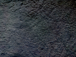 abstract dark gray shaggy fur texture closeup with soft gradient light and copy space for banner backdrop or cozy wallpaper design evoking mysterious ambiance