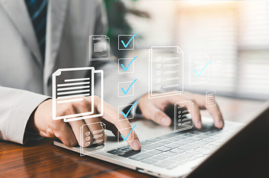 Businessman using laptop with digital document verification and approval checklist interface. Online workflow management, compliance control, paperless office and secure business process automation.