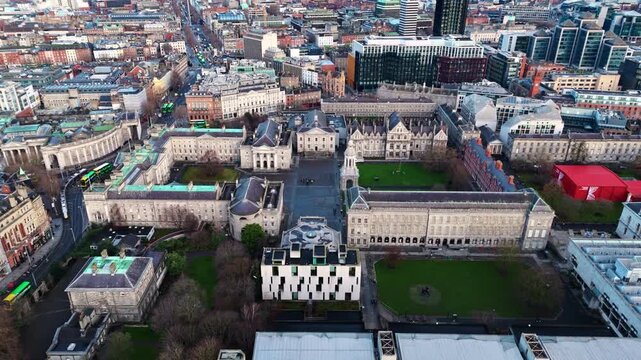aerial drone shot capturing the trinity college university campus in the heart od the Irish capital of Dublin at sunrise with students and tourists alike wandering about with fields and trees around