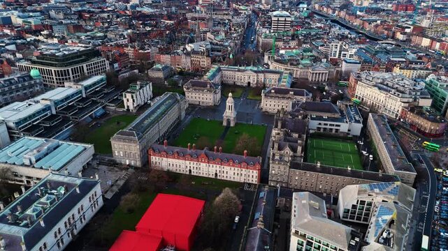 aerial drone shot capturing the trinity college university campus in the heart od the Irish capital of Dublin at sunrise with students and tourists alike wandering about with fields and trees around
