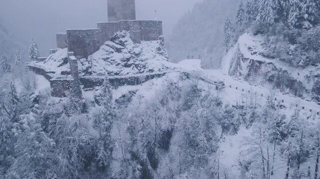 Snow-covered pine forest with Zilkale Castle rising in the background in Rize, Turkey. Atmospheric winter scenery with fog and mountains, ideal for travel, nature, history, and cinematic landscape con